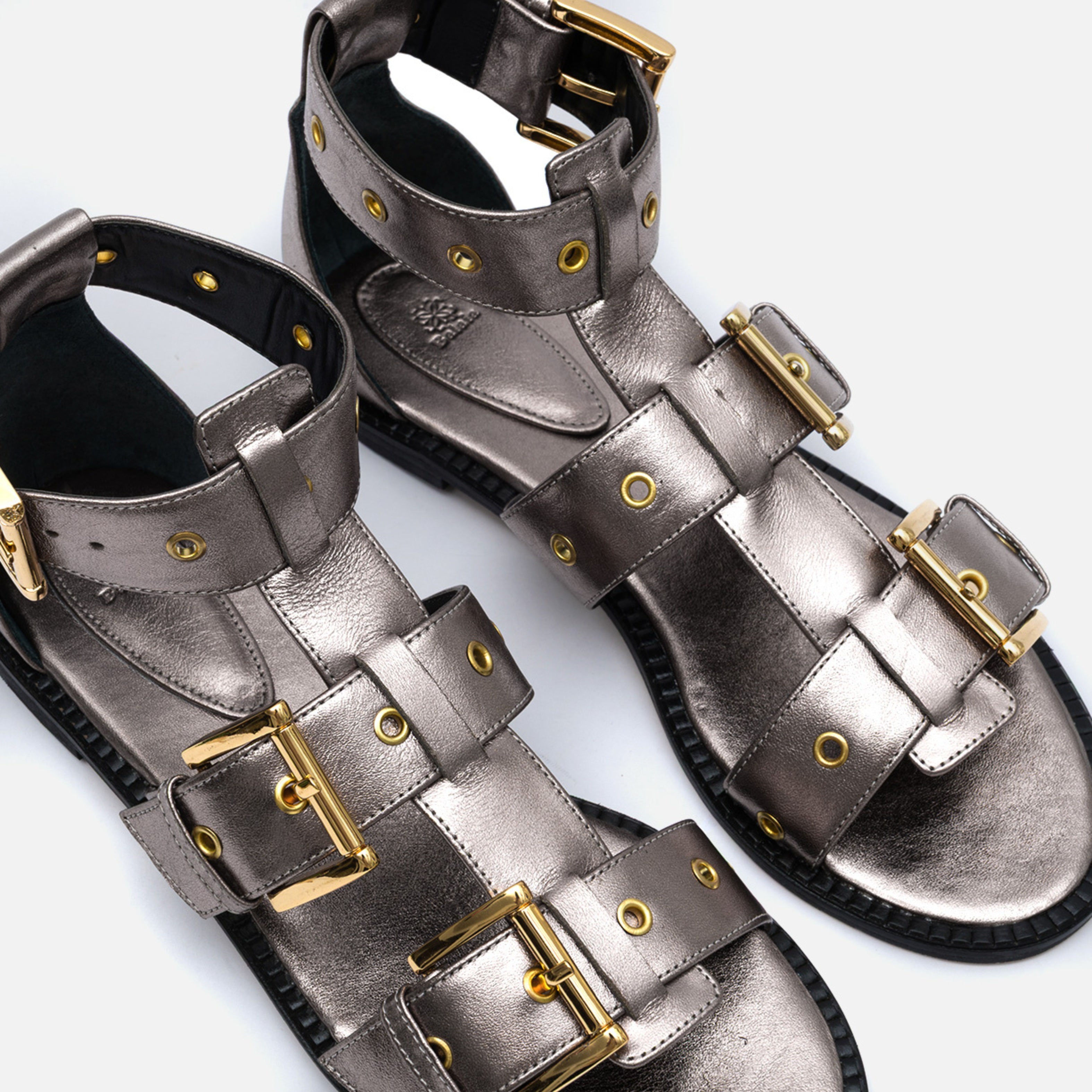 Sandália rasteira gladiadora em couro ônix com fivelas metálicas douradas